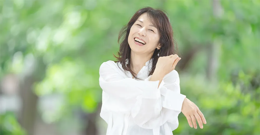 窓辺で身体を伸ばしている女性