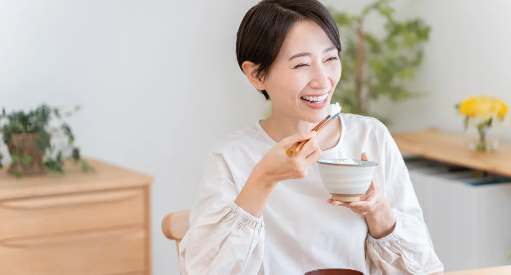 美味しそうにご飯を食べる女性